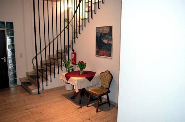 Treppenhaus mit kleinem gedecktem Tisch und Polsterstuhl